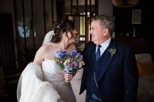 bride laughs with her father just before her wedding ceremony